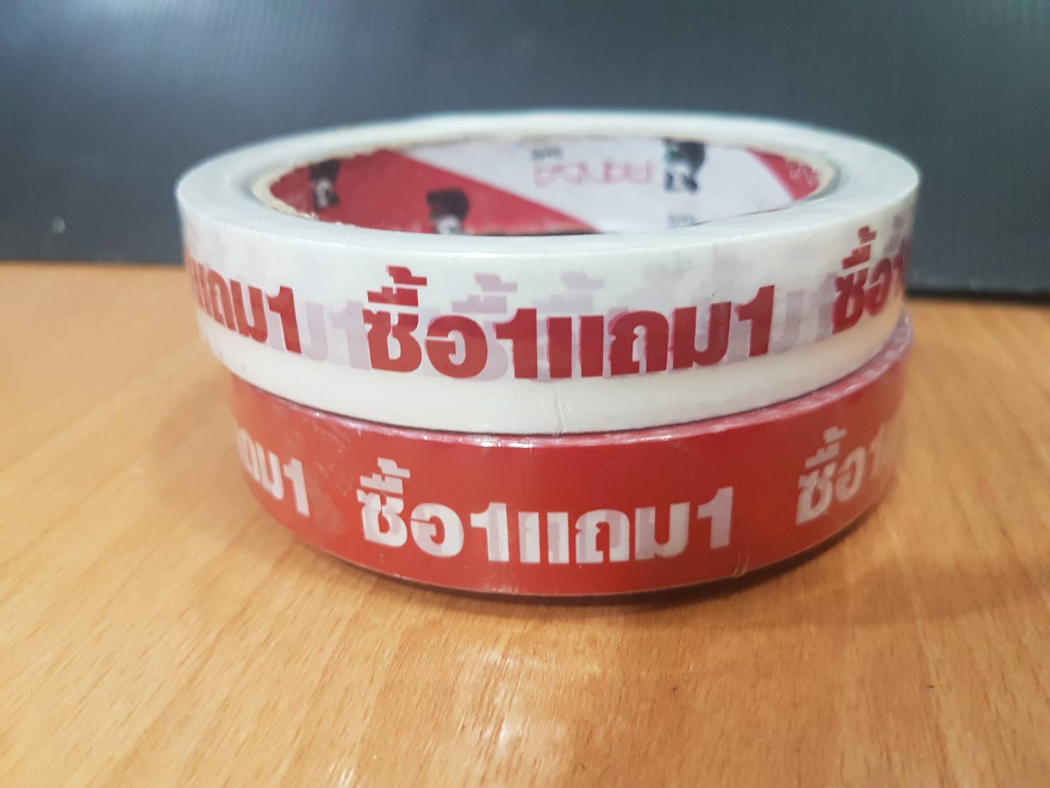 ขาย1ม้วน-เทปพิมพ์ลาย ซื้อ1แถม1-หน้ากว้าง 18มม ยาว 50หลา-เทปกาวตกแต่ง พิมพ์ข้อความ"ซื้อ1แถม1" พื้นแดงและพื้นขาว-เทปโอพีพี18มม